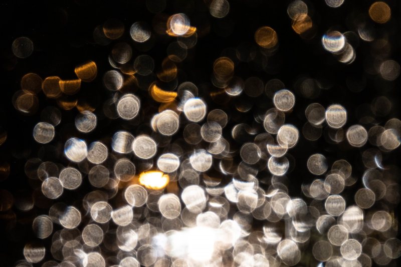 Raindrops on a dark window with the lights beyond out of focus